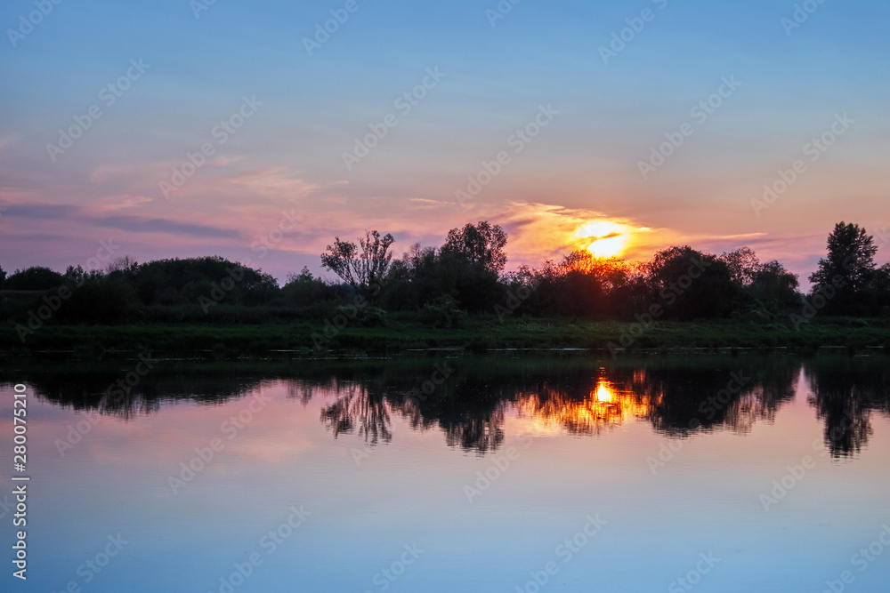 Beautiful sunset on the river with sky reflection and color gradients with copyspace for design