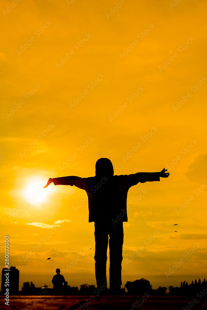 Silhouette of Girl Raising Her Hands or Open arms when sun going down Silhouette of Girl Raising Her Hands or Open arms when sun going down