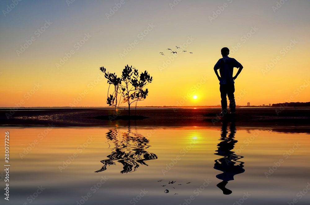 Silhouette of Man looking to the sun near the beach when the sun goes down