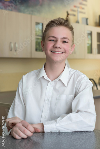 Free Download Back to school and happy time. Cute teenage boy is sitting at a desk indoors. Student is learning in class - GFXLoad