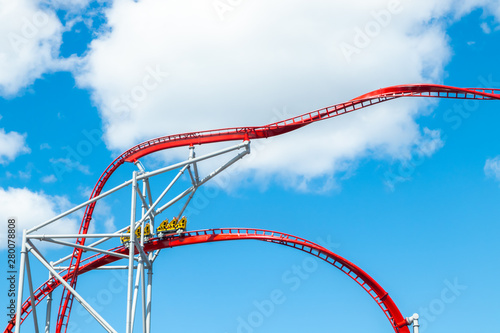 Roller Coaster in amusement park on blue sky background photo