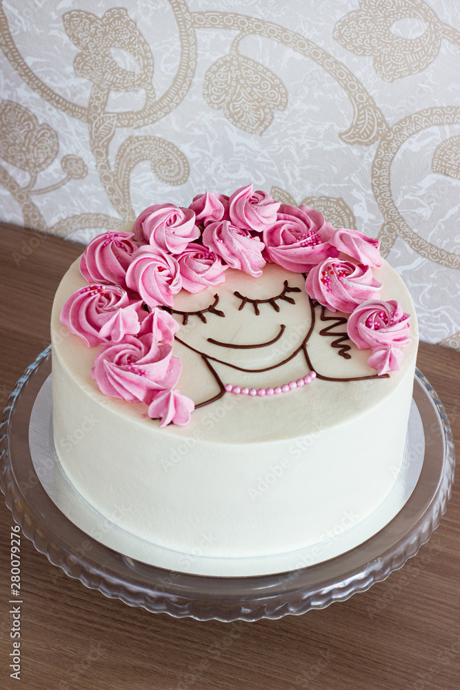 Festive cake with flowers from meringue and a girl face on a light background