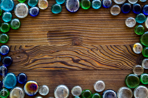 Shiny glass stones for decoration, creativity and craft on wooden background top view copyspace