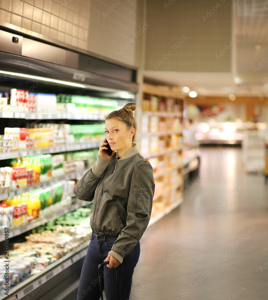Women  shopping in supermarket, reading product information