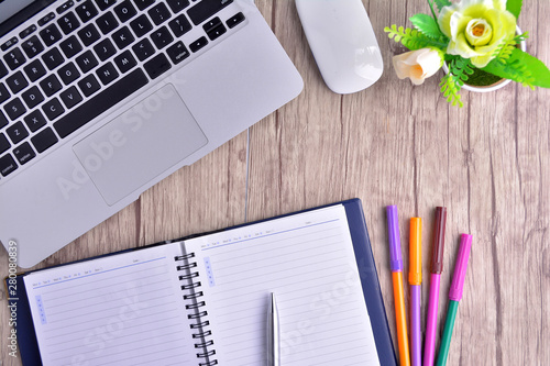 Laptop, notebook with magnifying glass on wooden table