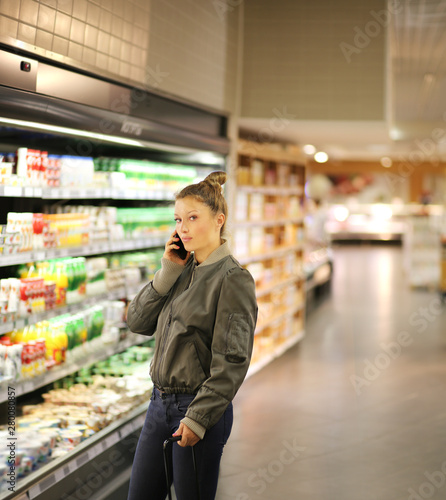 Women shopping in supermarket, reading product information