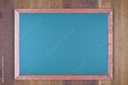 Green chalkboard on wooden background