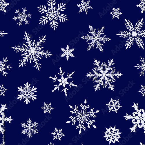 Christmas seamless pattern of complex big and small snowflakes in white colors on blue background