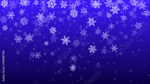 Christmas background of complex blurred and clear falling snowflakes in blue colors with bokeh effect