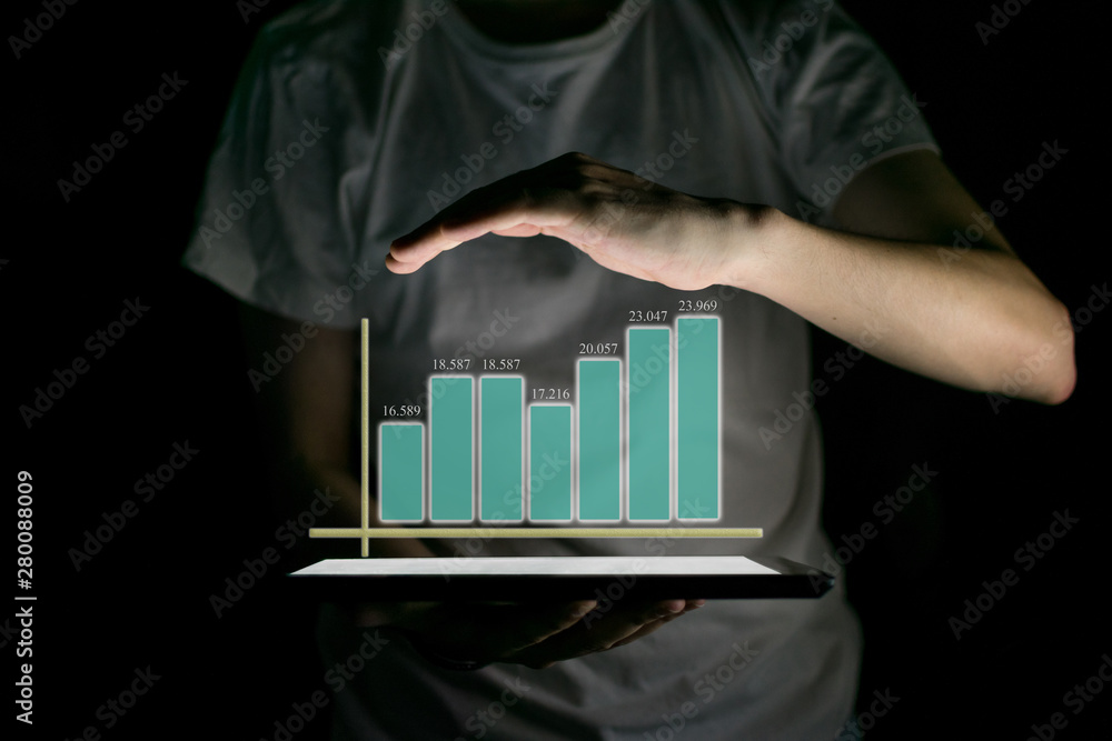 Businessman holding tablet and showing a growing virtual hologram of statistics Businessman holding tablet and showing a growing virtual hologram of statistics