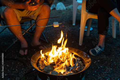 A Family around a camp fire roasting marshmallows photo