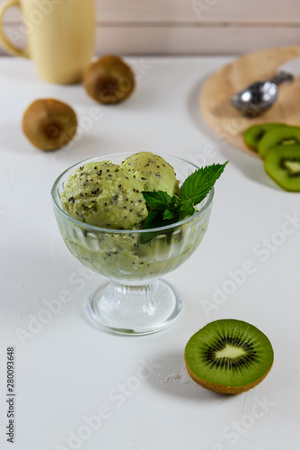 Ice cream in a bowl from kiwi with mint. Homemade dessert, frozen treats.