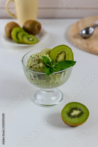 Ice cream in a bowl from kiwi with mint. Homemade dessert, frozen treats.