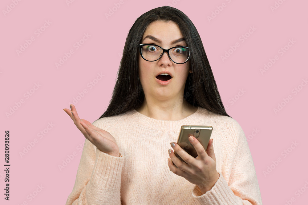 Young beautiful woman using mobile phone studio on white color background. Looking attentively at screen of cellphone, browsing web pages. Young beautiful woman using mobile phone studio on white color background. Looking attentively at screen of cellphone, browsing web pages.