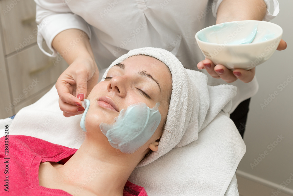 Face skin care. Beautician applying beauty oil mask on face using brush In spa salon Face skin care. Beautician applying beauty oil mask on face using brush In spa salon