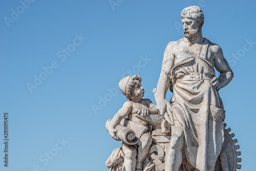 Sculpture of engineer and his scholar on Zoll Bridge in Magdeburg downtown, Germany, sunny day, blue sky
