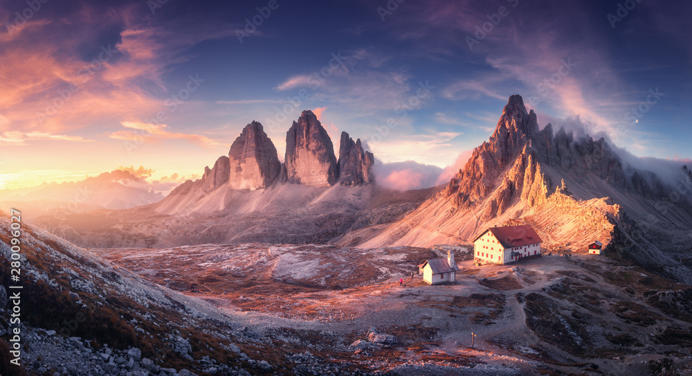 Mountain valley with beautiful house and church at sunset in autumn. Landscape with buildings, high rocks, colorful sky, clouds, sunlight. Mountains in Tre Cime park in Dolomites, Italy. Italian alps - obrazy, fototapety, plakaty 