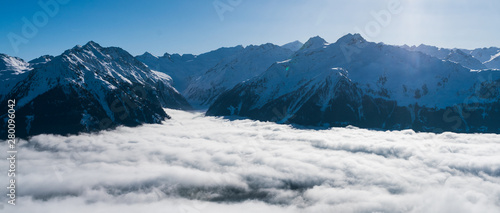Panoramic view over the Austrian alps covered in snow. High above the fog. photo
