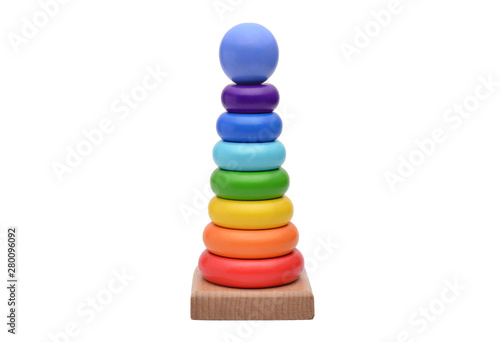 Toy pyramid from rainbow colored wooden rings with a ball head on top. Toy for babies to joyfully learn mechanical skills and colors. Studio shot. Isolated on white background