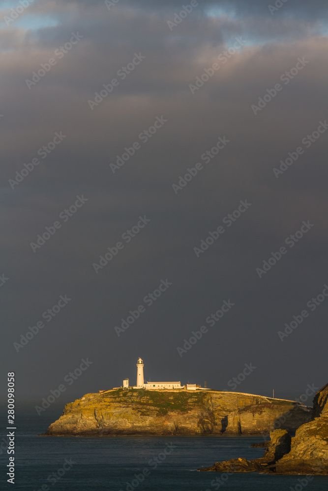 Obraz na plátně Lighthouse on rocky outcrop in morning light, portrait