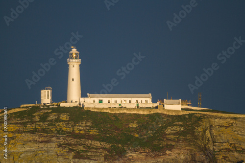 Lighthouse on rocky outcrop in morning light, copyspace