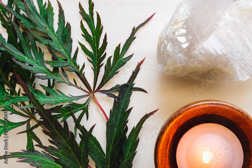 Peach Candle with Quartz and Japanese Maple Leaves on Wood photo