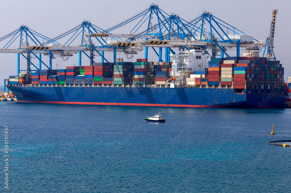 A large container ship is loaded in the cargo port of Malta.