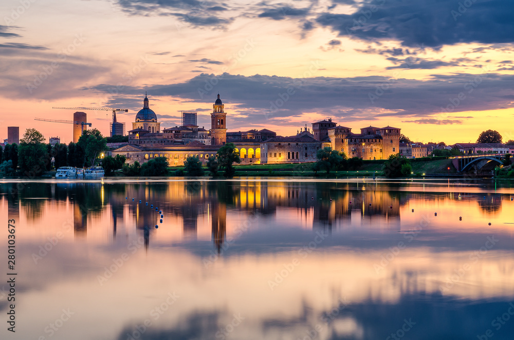 View of the city of Mantua at sunset reflected on the Middle Lake on the Mincio River