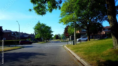Viewpoint of City Suburb Four-Way Stop Sign Intersection Road With Traffic in Day.  Vehicles Stop and Go at All-Way Stop Intersection Street.