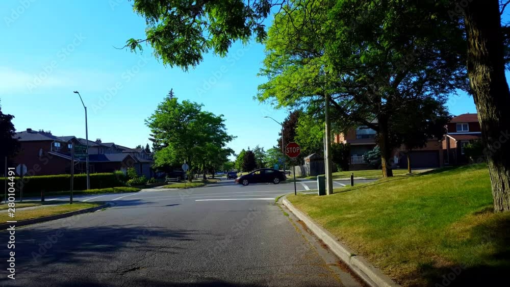 Viewpoint of City Suburb Four-Way Stop Sign Intersection Road With Traffic in Day. Vehicles Stop and Go at All-Way Stop Intersection Street. Viewpoint of City Suburb Four-Way Stop Sign Intersection Road With Traffic in Day. Vehicles Stop and Go at All-Way Stop Intersection Street.