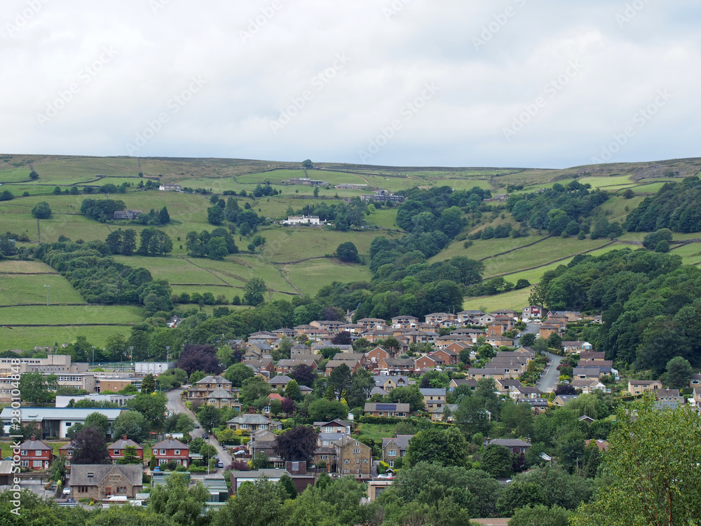 a view of mytholmroyd from above in west yorkshire countryside surrounded by trees and fields and farms