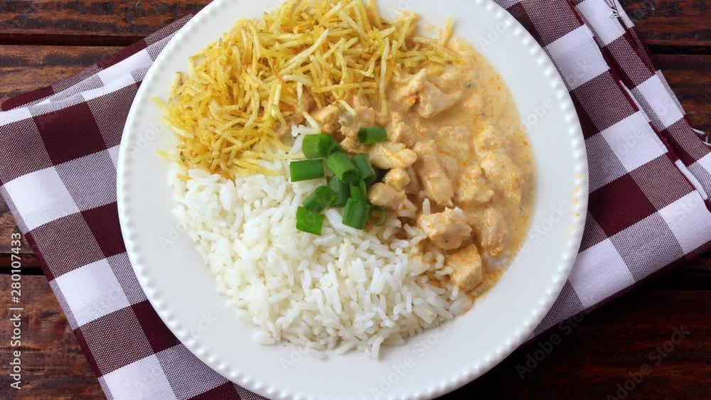 Chicken stroganoff, is a dish originating from Russian cuisine that in Brazil is composed of sour cream with tomato extract, rice and potato chips. Chicken stroganoff, is a dish originating from Russian cuisine that in Brazil is composed of sour cream with tomato extract, rice and potato chips.