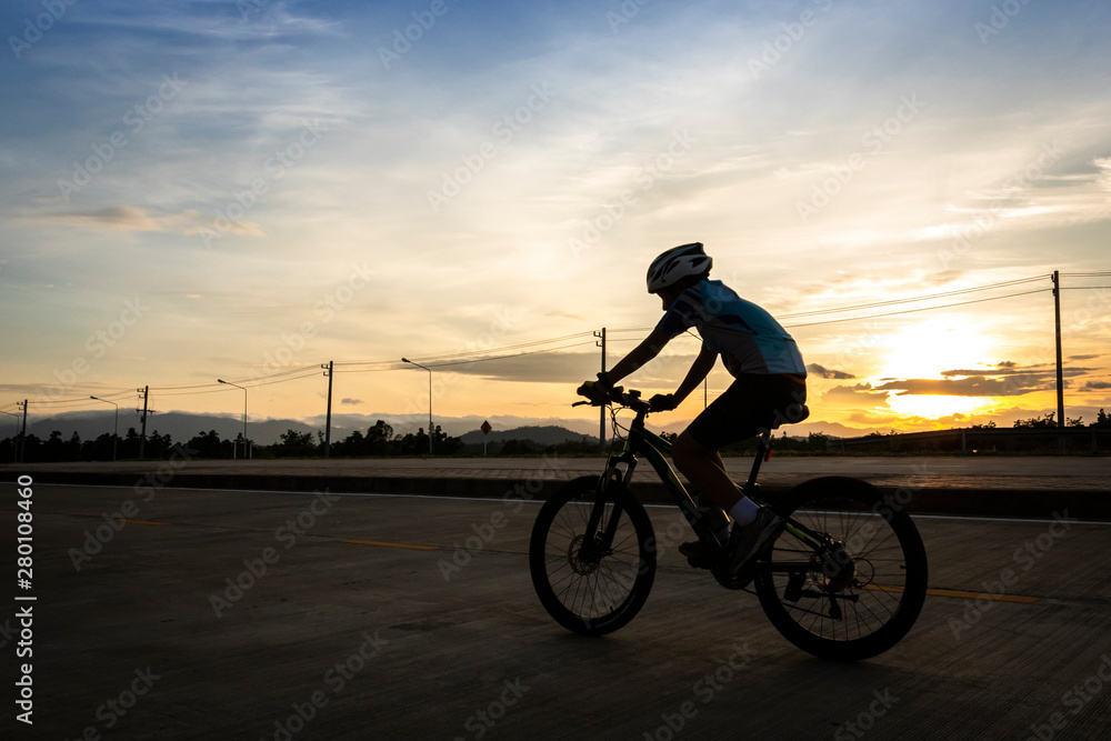 man riding bicycle on the highway at dusk