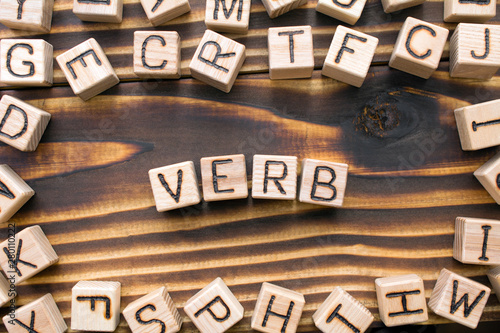 word verb composed of wooden cubes with letters, Part of speech concept scattere Fototapet