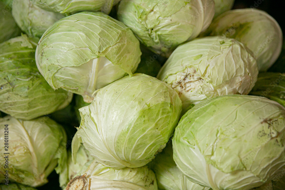 a pile of heads of green cabbages at a farmer's market stall for sale a pile of heads of green cabbages at a farmer's market stall for sale