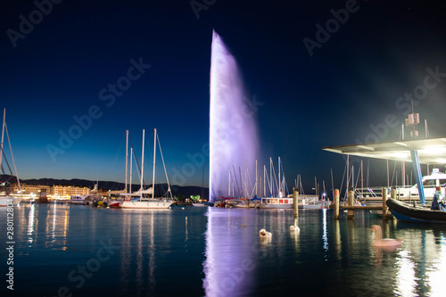 Long exposure capture of the Jet d'eau with swans swimming in a boat yard in Geneva Switzerland 