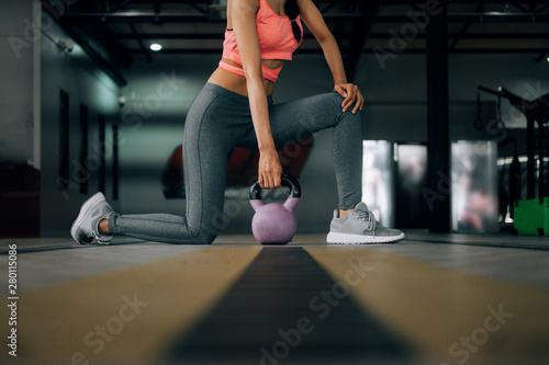 sport woman at fitness gym club doing exercise for arms with kettlebell and showing muscle bodybuilding  fitness concept  sport concept