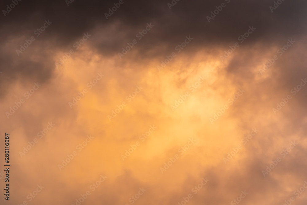 Stormy sky at twilight with clouds in various shades of orange and gray