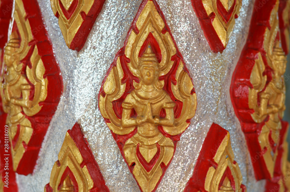 The golden stucco statue of a deity in the temple of Thailand