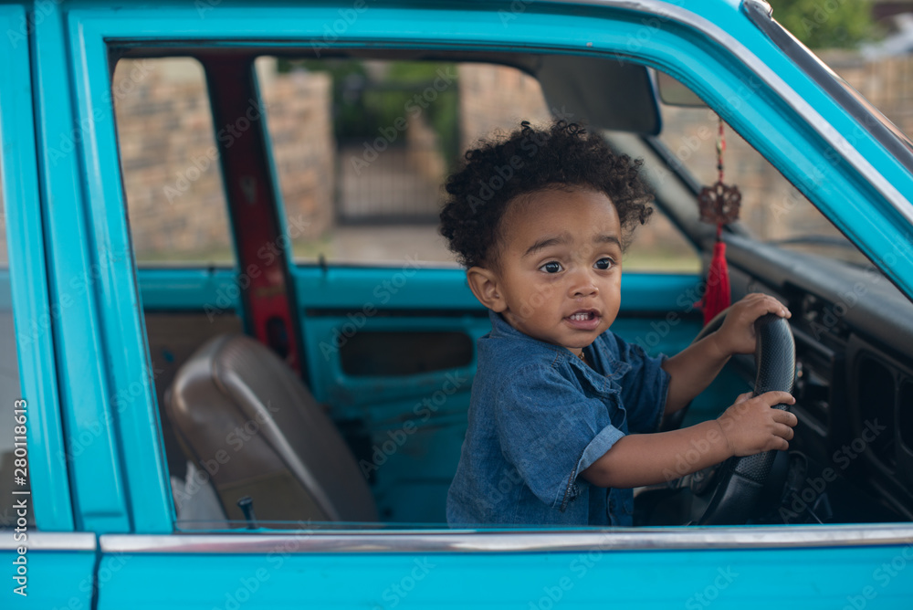 little boy in a car holding onto steering wheel little boy in a car holding onto steering wheel