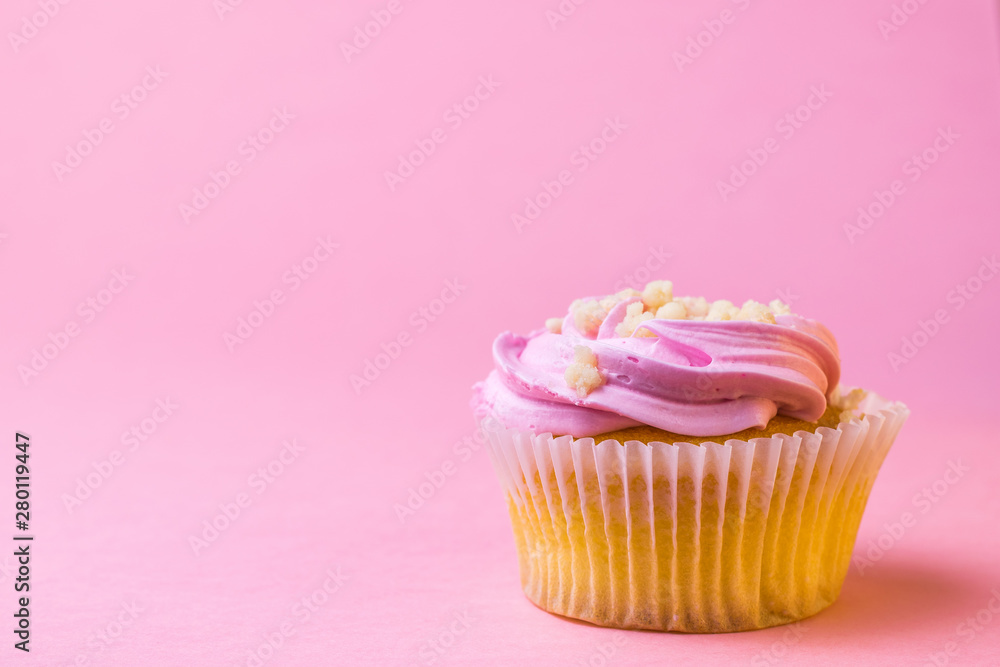 Festive cupcake with fruit on a pink background.