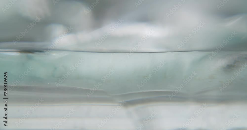 Transparent fluid moving slowly towards the camera, building waves. Static macro shot. Transparent fluid moving slowly towards the camera, building waves. Static macro shot.