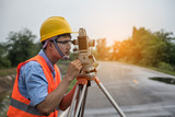Young man engineer is using Surveyor equipment tacheometer or theodolite worker on the road.