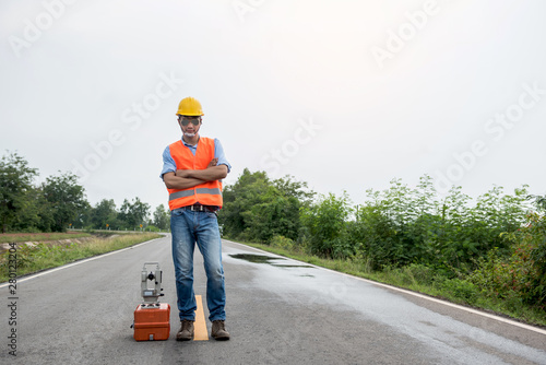 Civil engineer with Surveyor equipment tacheometer or theodolite outdoors at construction site on the road.