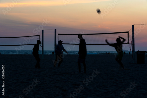 Wallpaper Mural Silhouettes of four volleyball players on the beach at sunset with ocean views and a colorful sky in the background. Huntington Beach, Orange County, California, USA. Torontodigital.ca