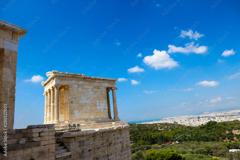 Beautiful view to the ancient greek temple of Athena Nike in acropolis of athens greece against bright blue sky with clouds