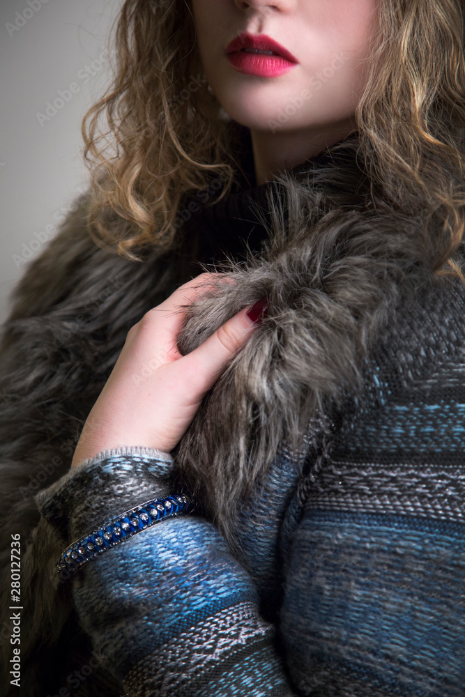 fashionable young woman in fur knit coat