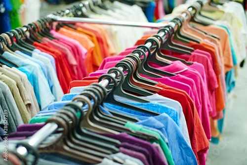 Multicolor clothes hanging on hangers in a second-hand store