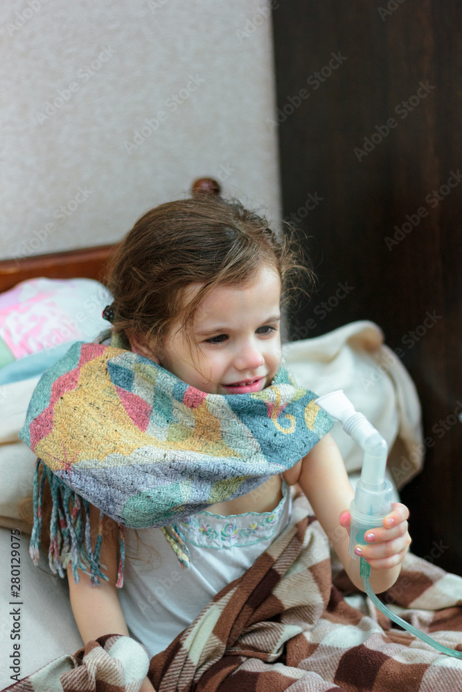 Child with respiratory illness making inhalation with inhaler. Child with respiratory illness making inhalation with inhaler.