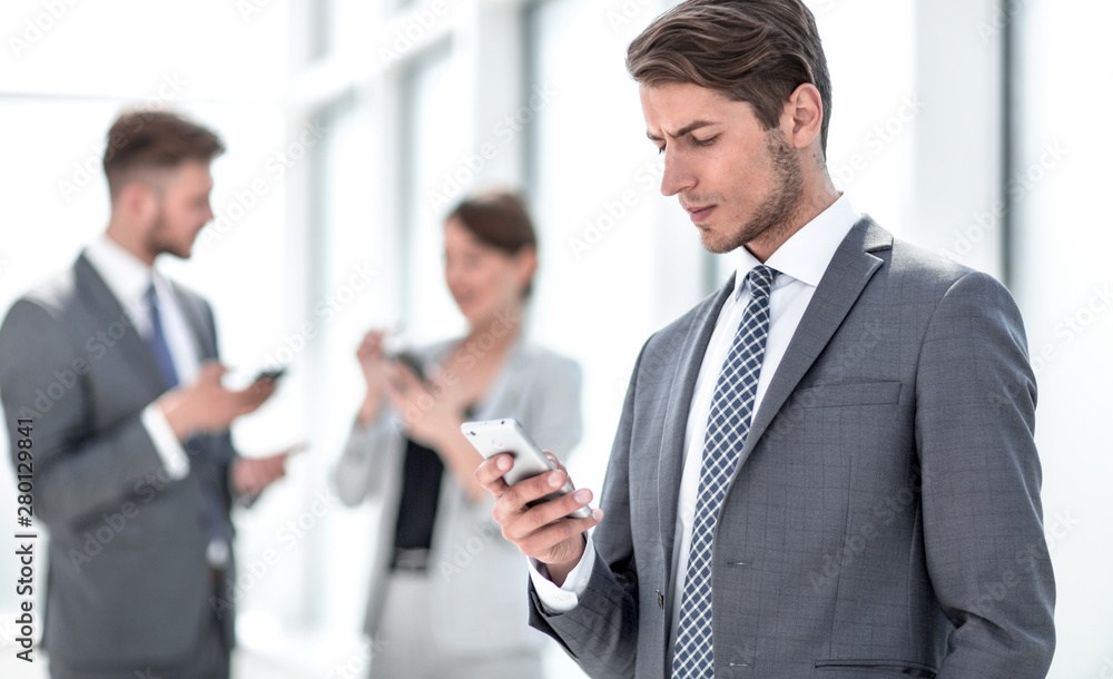 serious businessman reading SMS on his smartphone. serious businessman reading SMS on his smartphone.